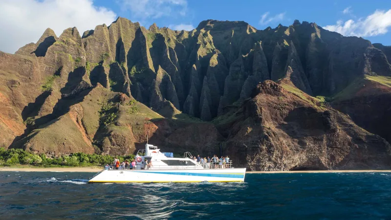 Catamaran in the sunset light on a Na Pali Coast boat tour dinner cruise from Port Allen, Kauai