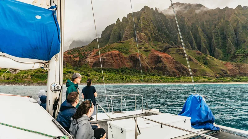 Sailing catamaran at sunset on a Na Pali Coast boat tour with dinner from Port Allen, Kauai