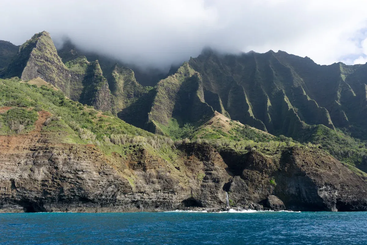 Cliff face with caves at sea level along the Na Pali Coast on Kauai Napali Coast boat tours