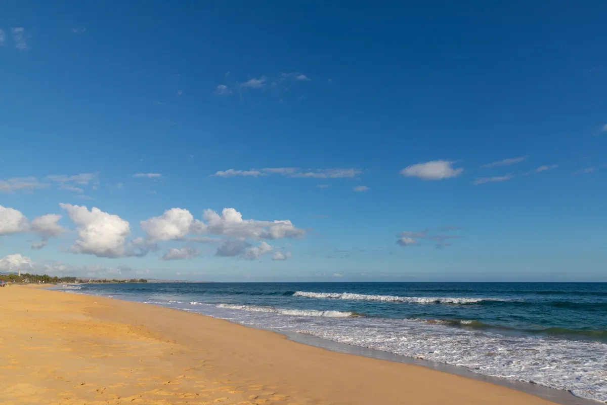 Long sandy shore of Kekaha Beach Park on west Kauai near Kikiaola Harbor and Napali Coast boat tours