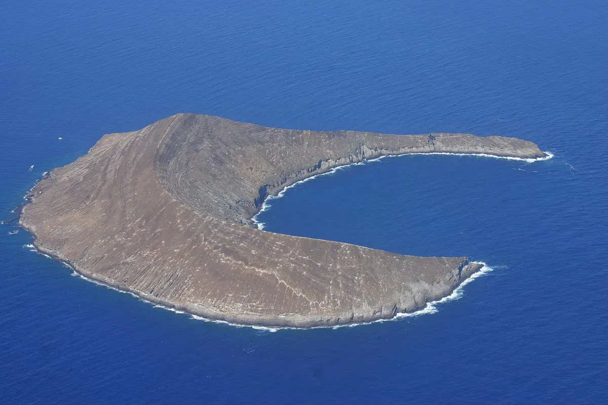 Aerial view of the crescent of Lehua Islet beside Niihau on a Kauai Na Pali Coast and Niihau full day tour